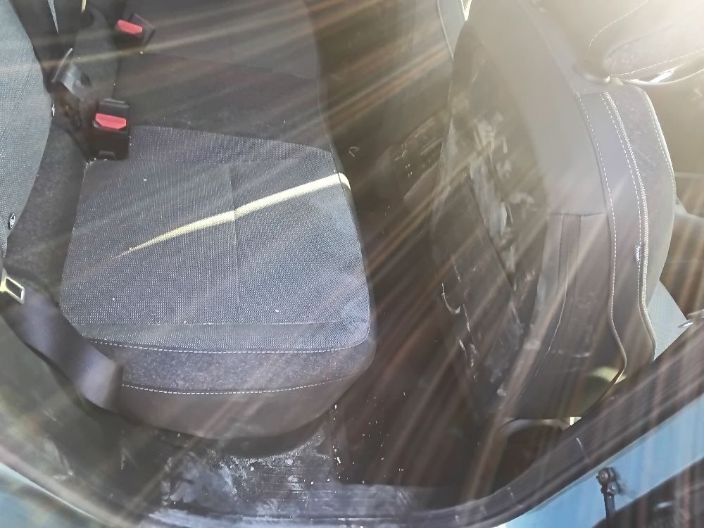 Rear seats seen through the window, showing ordinary light use with no visible damage or staining.